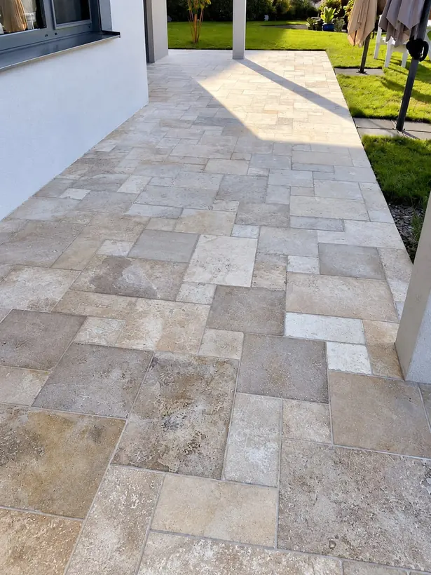 Weg aus Natursteinplatten in verschiedenen Formaten entlang der Hauswand